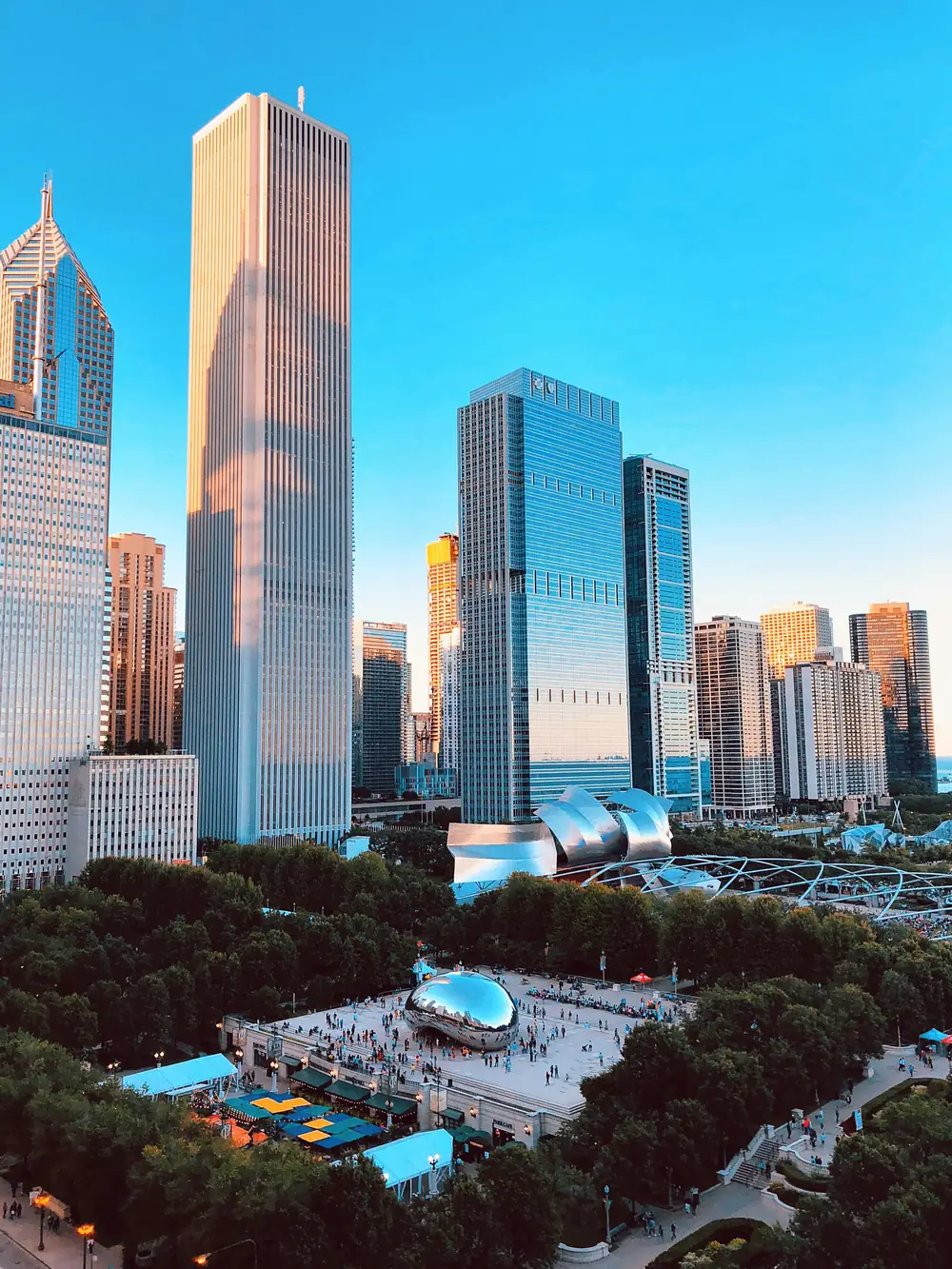 Millennium Park and the Chicago skyline in clear afternoon light, Cloud Gate in the plaza below.